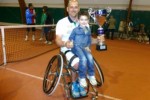 Antonio Moretto, con il figlio in braccio, regge un trofeo di tennis in carrozzina appena vinto