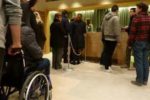 Una persona con disabilità motoria all'entrata di un teatro