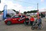 Persone con disabilità a fianco della Suzuki Swift con comandi speciali, che consente loro di partecipare al "Rally Italia Talent"