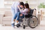 Un giovane caregiver assiste un'altrettanto giovane persona con disabilità