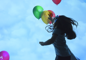 Bambina che gioca con dei palloncini colorati