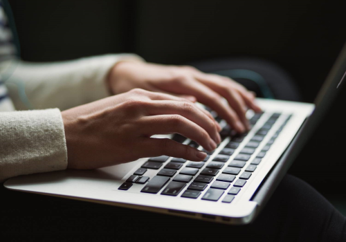 Mani di persona che lavorano sulla tastiera di un computer