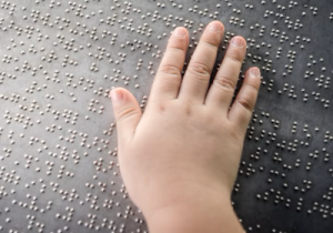 Dita di bambino che leggono in Braille