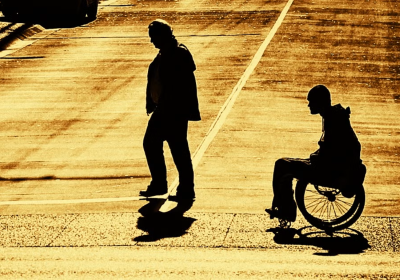 Persona con disabilità dietro a persona senza disabilità