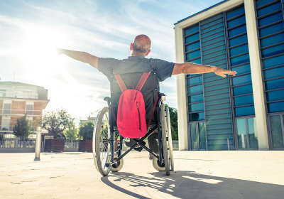 Persona con disabilità fotografato di spalle con le braccia aperte