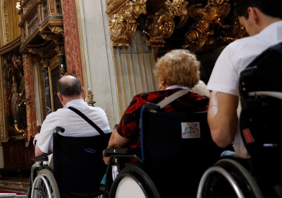 Persone in carrozzina in chiesa, fotografate di spalle