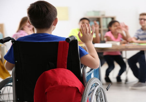Alunno con disabilità di spalle, che alza la mano