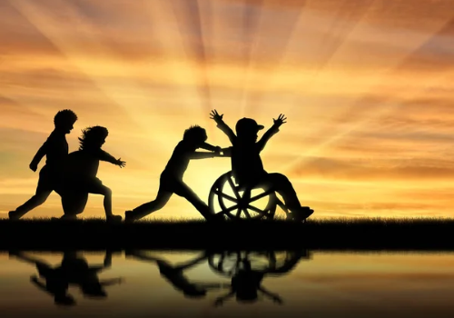 Bimbi con e senza disabilità che giocano con il sole sullo sfondo
