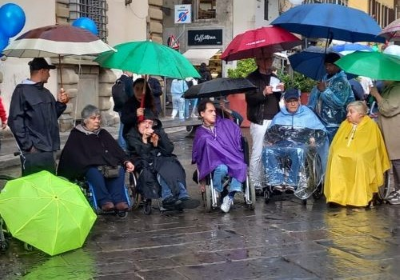 Alcune delle persone con e senza disabilità che il 5 maggio scorso a Firenze hanno partecipato al presidio di protesta promosso dall’AVI Toscana (Associazione Vita Indipendente della Toscana) sotto la pioggia, davanti al palazzo della Presidenza della Regione Toscana