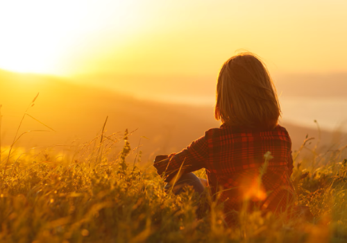 Ragazza che guarda il sole all'alba o al tramonto