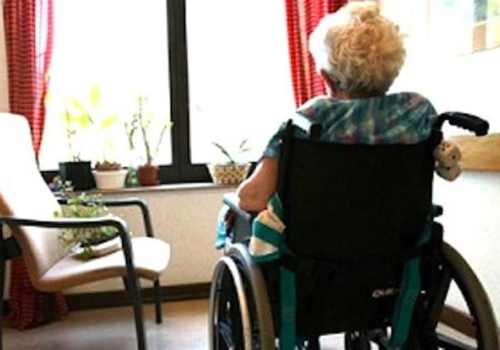 Signora anziana in carrozzina di spalle