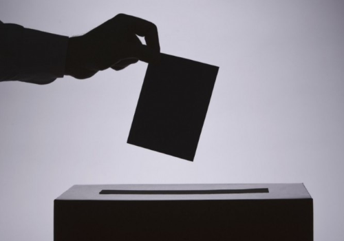 Mano che deposita una scheda nell'urna elettorale