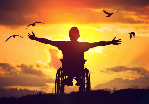 Persona con disabilità di fronte al sole con braccia aperte