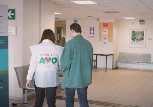 Una persona con disabilità visiva in ospedale, insieme a una volontaria dell'AVO