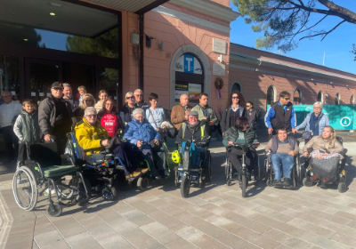 Foto di gruppo per una serie di partecipanti alla "Passeggiata inclusiva" di Gorizia, davanti alla stazione ferroviaria
