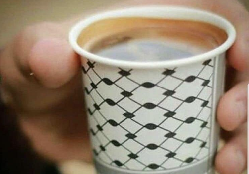 Mano che regge un bicchierino con del caffè