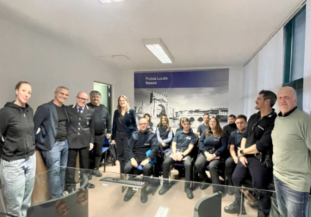 Un gruppo di agenti della Polizia Locale di Rimini con Alessandra Urbinati, presidente dell'Associazione Rimini Autismo, il sindaco della città Jamil Sadegholvaad, il comandante della Polizia Locale Andrea Rossi e altri genitori di Rimini Autismo