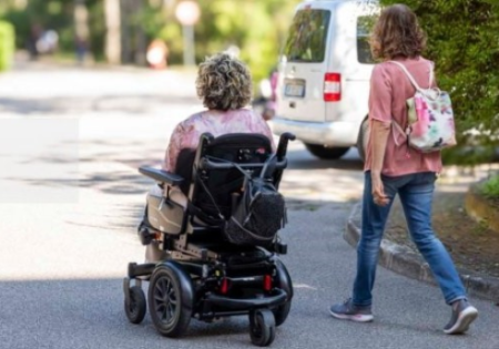 Una persona con disabilità insieme all'assistene personale