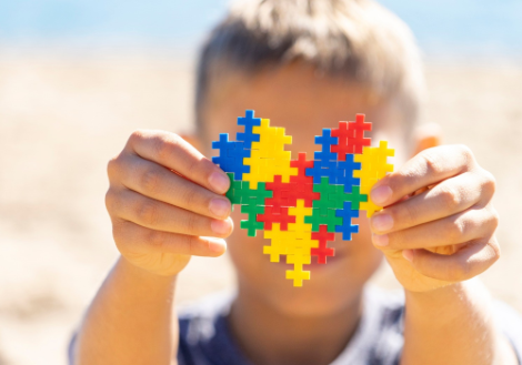 Bimbo con pezzi di puzzle in mano e il volto nascosto