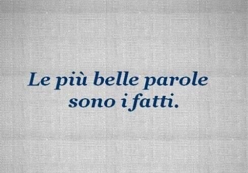 Scritta "Le più belle parole sono i fatti" su sfondo grigio