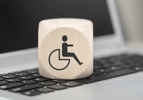 Cubo con il logo della disabilità sopra a una tastiera