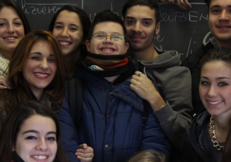 Un ragazzo con sindrome di Down insieme a compagni e compagne di scuola