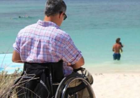 Persona in carrozzina davanti al mare