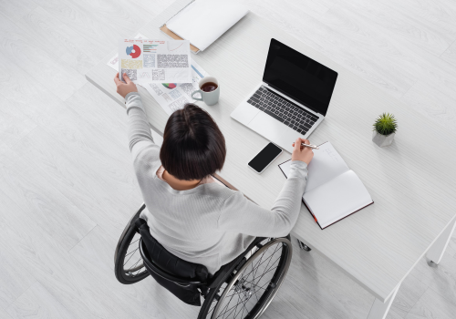Persona con disabilità in carrozzina al lavoro, fotografata dall'alto