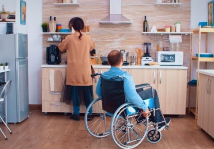 Persona con disabilità in carrozzina in cucina