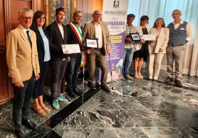 La consegna del premio dell'AICE "6con noi". Da sinistra l’assessore regionale ai Trasporti Luigi Bertschy; l’assessora al Turismo di Doues Corinne Cuaz; il vicesindaco di Doues Daniel Diemoz; il Sindaco di Doues Giorgio Abram; il presidente della Regione Renzo Testolin; i genitori della minore di Doues; la coordinatrice dell’Istituzione Scolastica Grand Combin Simona d’Agostino; il presidente dell'AICE Valle d’Aosta Manuele Amateis