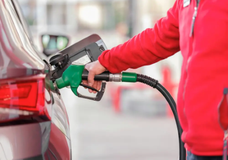 Benzinaio con pompa di carburante che fa rifornimento