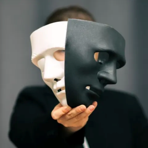 Persona con una maschera bifronte davanti al volto