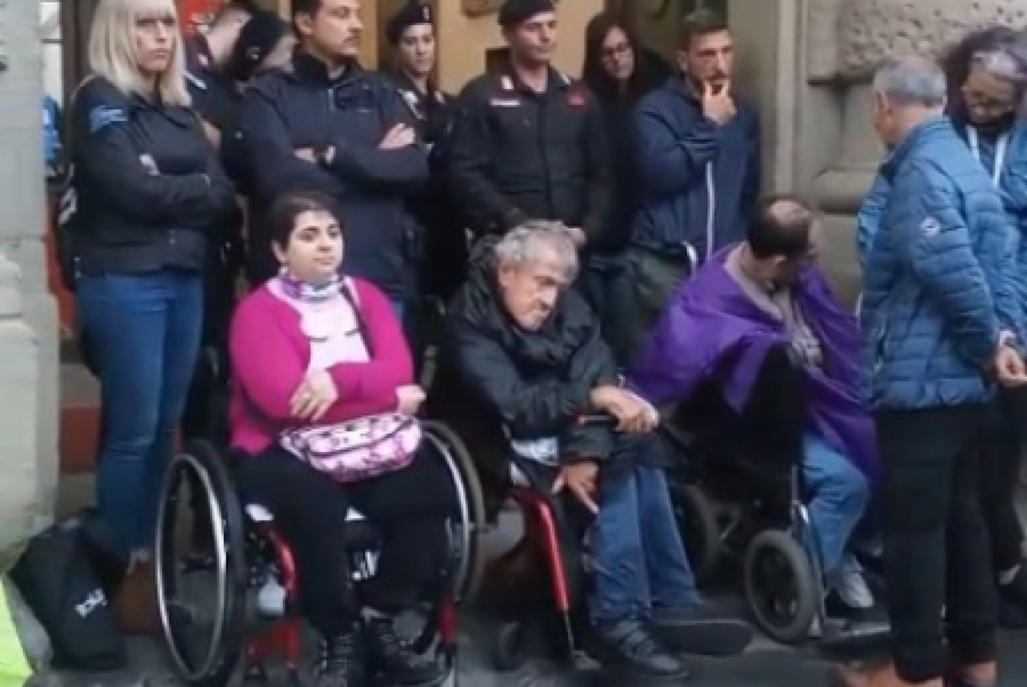 Alcune delle persone con e senza disabilità che il 5 maggio hanno partecipato al presidio di protesta promosso dall’AVI Toscana (Associazione Vita Indipendente della Toscana) sotto la pioggia, davanti all’ingresso del palazzo della Presidenza della Regione, a Firenze