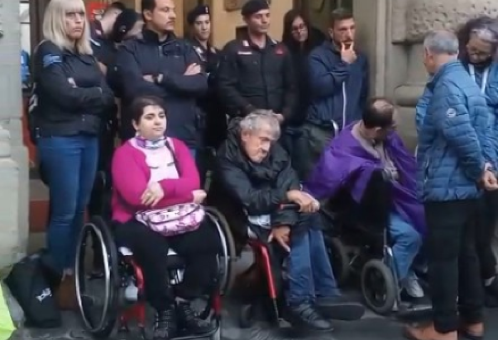Alcune delle persone con e senza disabilità che il 5 maggio hanno partecipato al presidio di protesta promosso dall’AVI Toscana (Associazione Vita Indipendente della Toscana) sotto la pioggia, davanti all’ingresso del palazzo della Presidenza della Regione, a Firenze