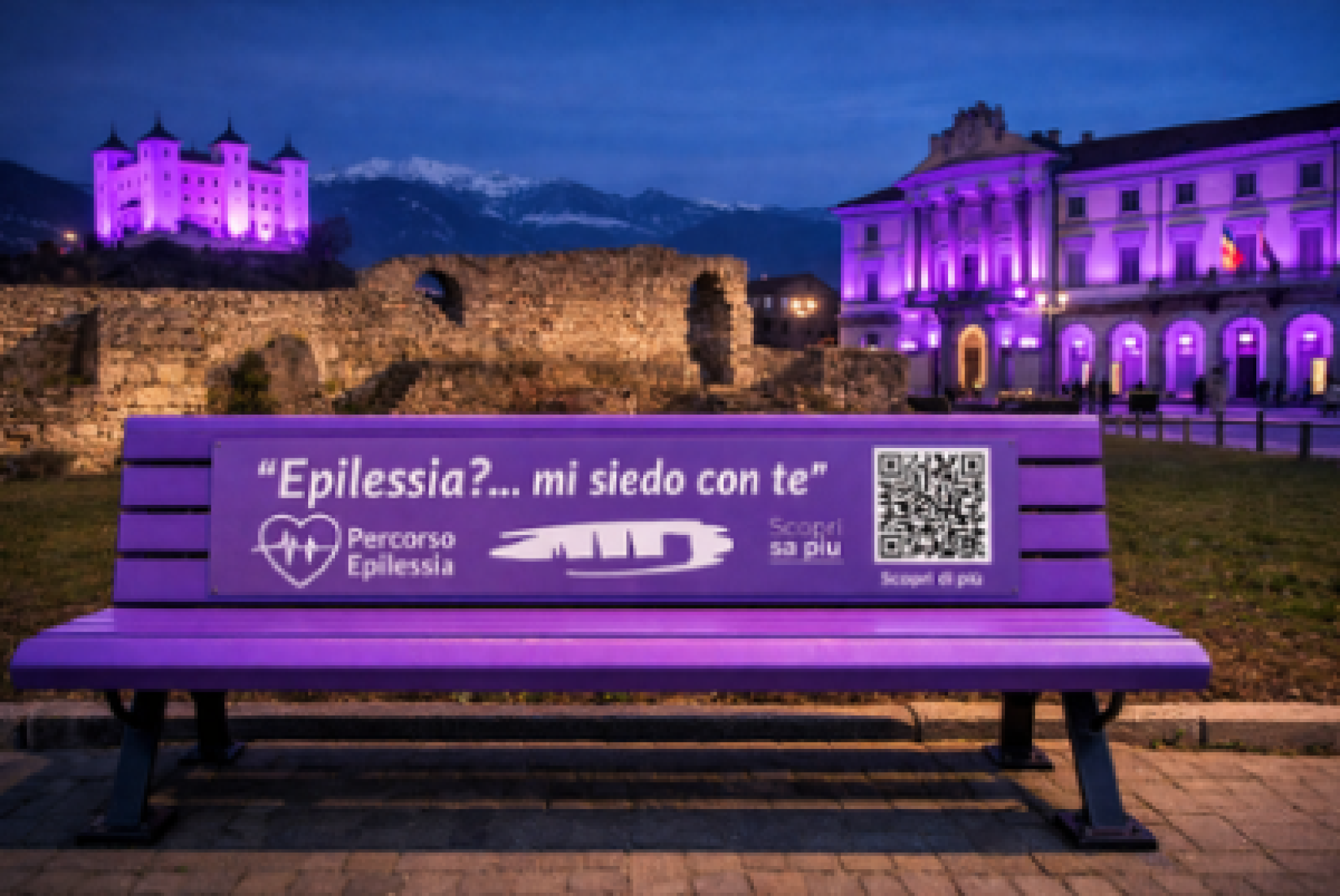 In questa immagine, realizzata con l'intelligenza artificiale, sono raffigurate sia la panchina viola che verrà inaugurata ad Aosta il 9 febbraio, sia il Palazzo Comunale della Città e il Castello di Aymavilles che in quello stesso giorno si illumineranno di viola