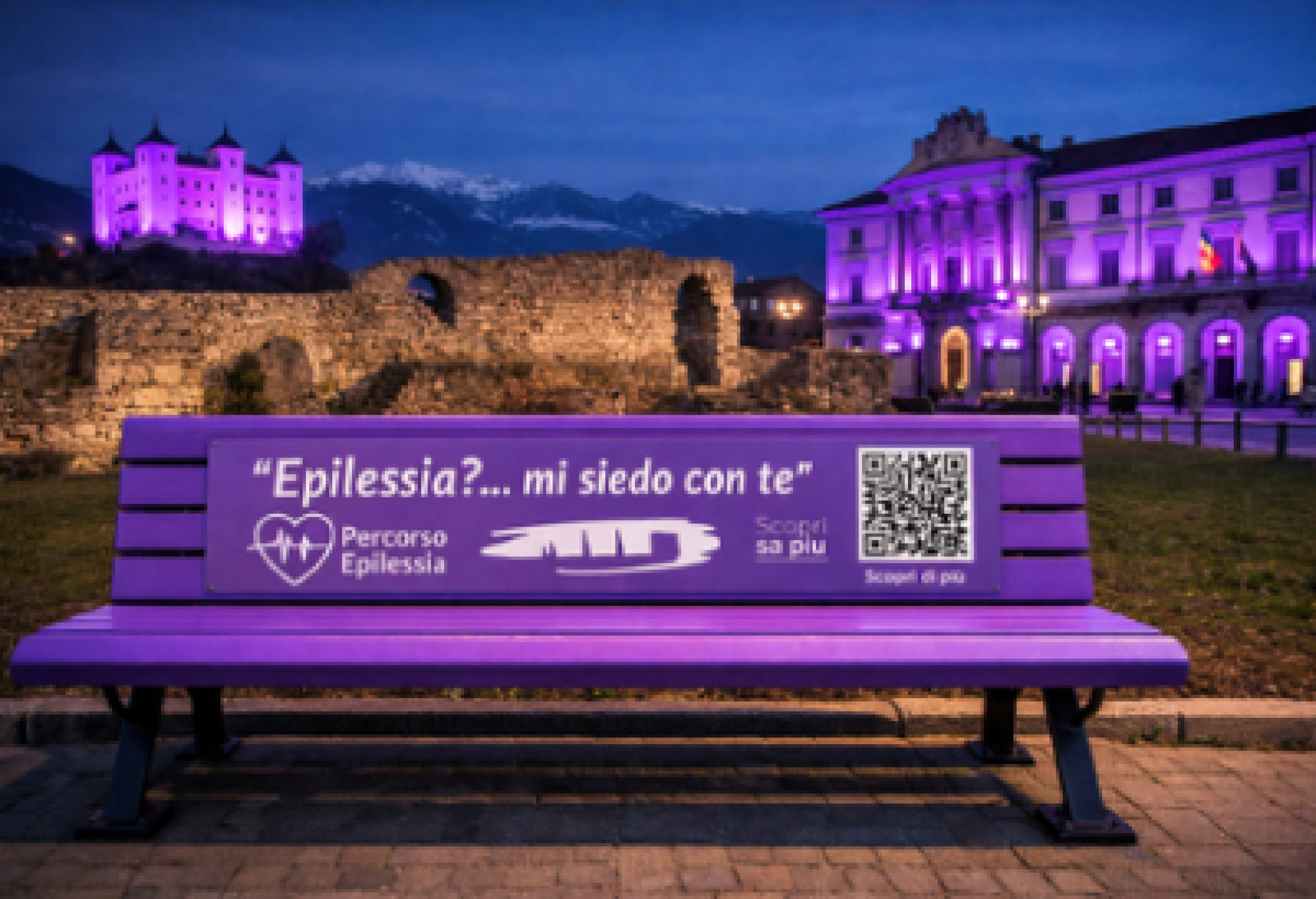 In questa immagine, realizzata con l'intelligenza artificiale, sono raffigurate sia la panchina viola che verrà inaugurata ad Aosta il 9 febbraio, sia il Palazzo Comunale della Città e il Castello di Aymavilles che in quello stesso giorno si illumineranno di viola