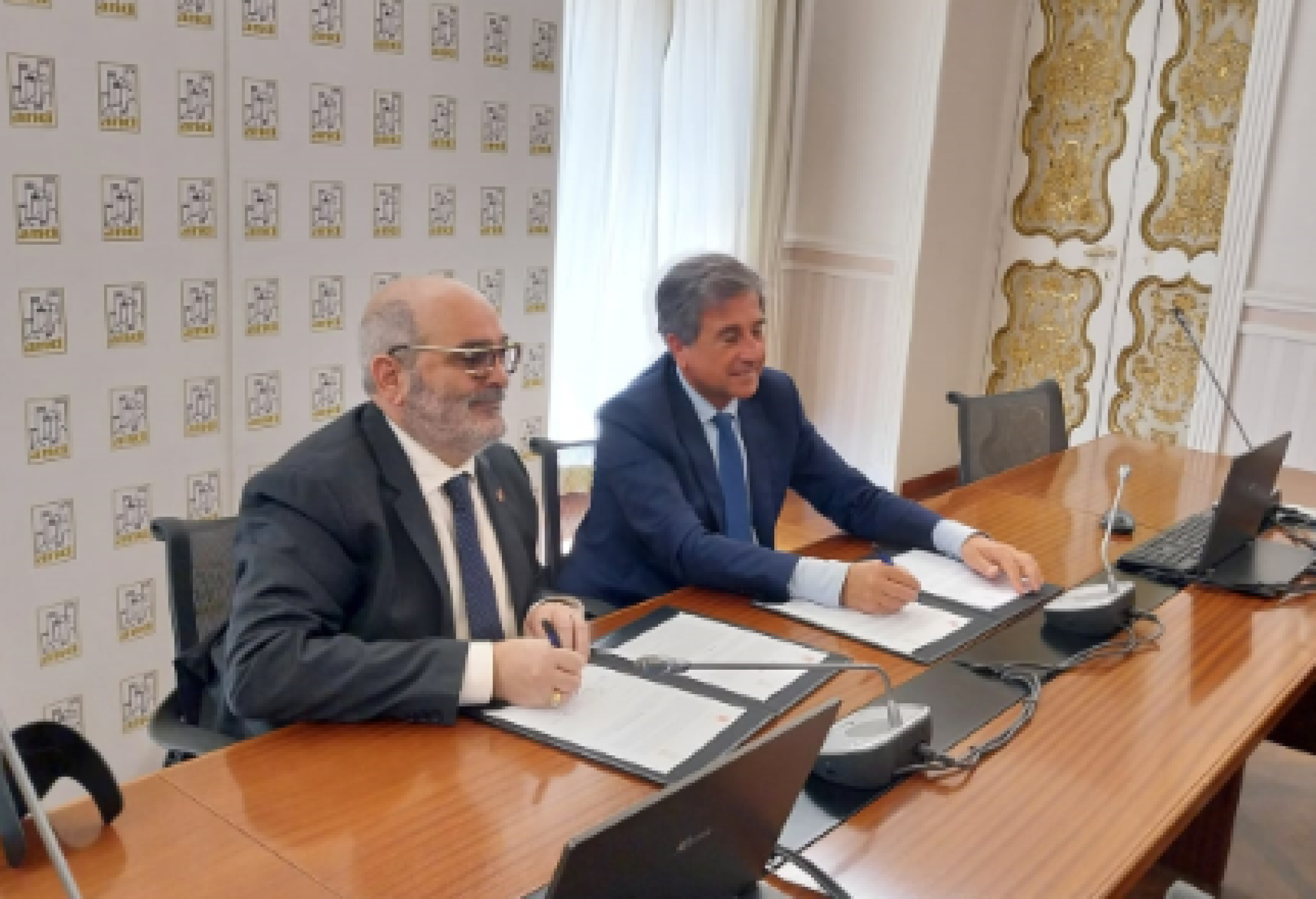 Il presidente dell'AISM Francesco Vacca (a sinistra) e il vicepresidente dell'ANCI Roberto Pella sottoscrivono il protocollo d'intesa presso la sede nazionale dell'ANCI