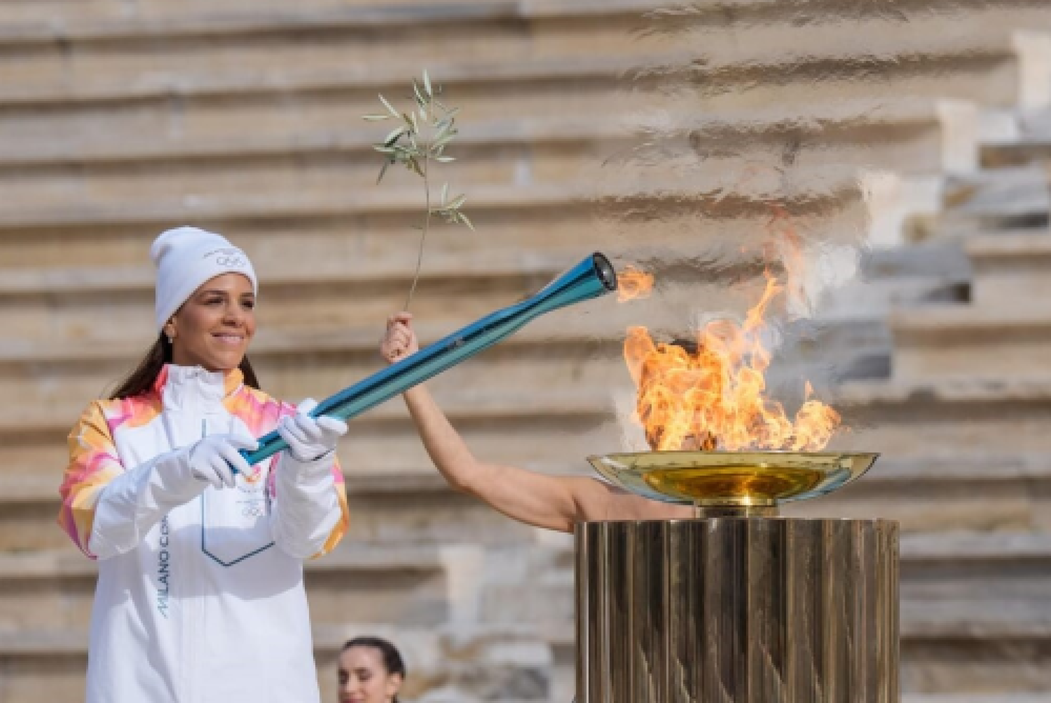 L'accensione della torcia olimpica di Milano-Cortina ad Atene con la pallanuotista greca Elena Xenaki (foto LaPresse)