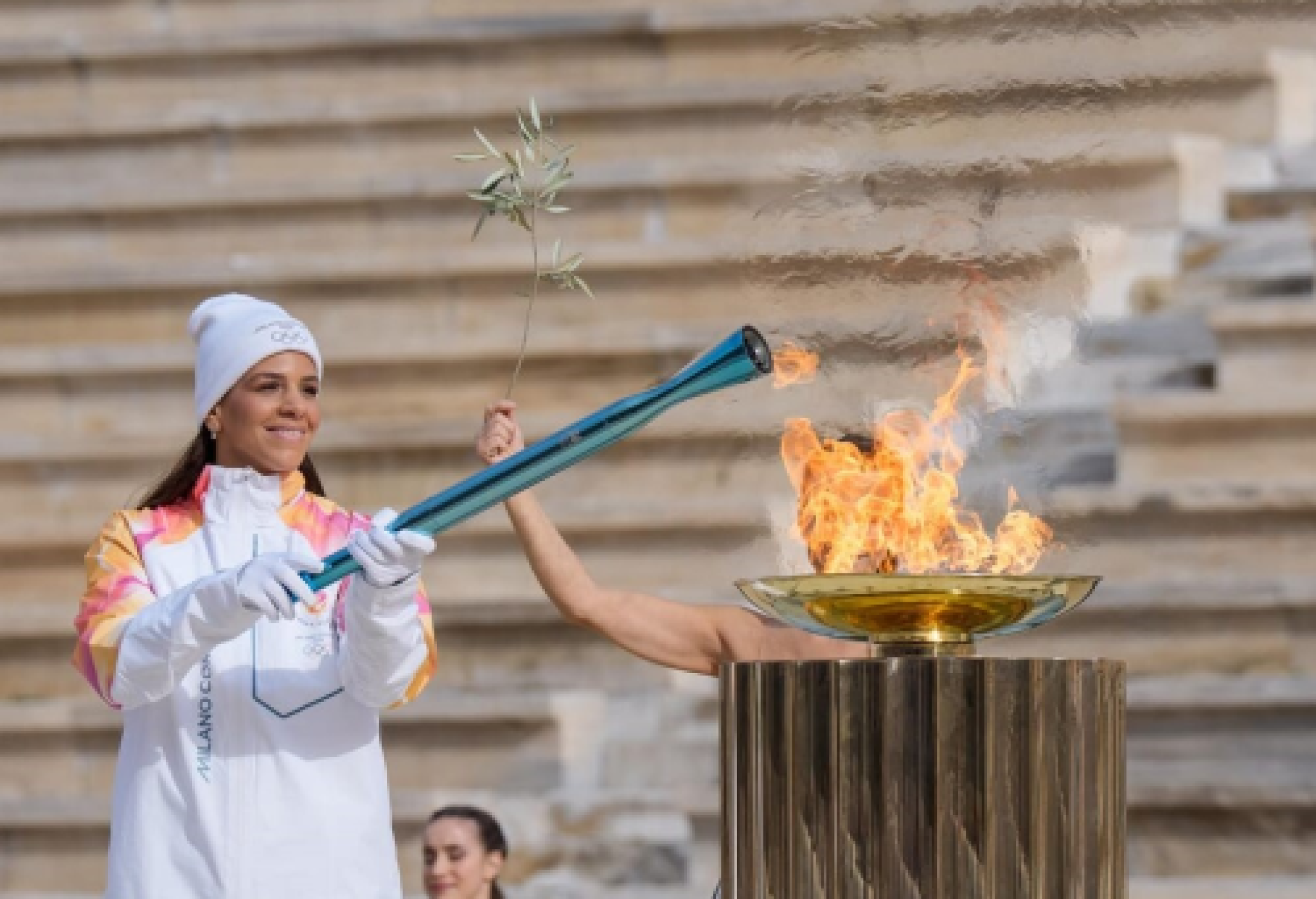 L'accensione della torcia olimpica di Milano-Cortina ad Atene con la pallanuotista greca Elena Xenaki (foto LaPresse)