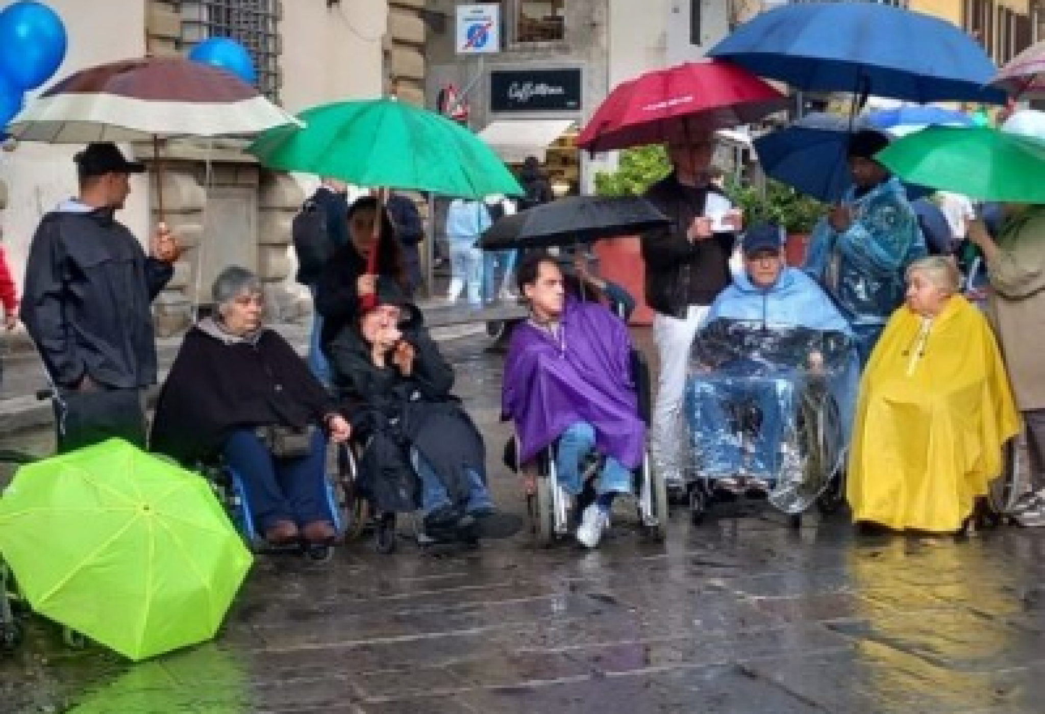 Alcune delle persone con e senza disabilità che il 5 maggio scorso a Firenze hanno partecipato al presidio di protesta promosso dall’AVI Toscana (Associazione Vita Indipendente della Toscana) sotto la pioggia, davanti al palazzo della Presidenza della Regione Toscana