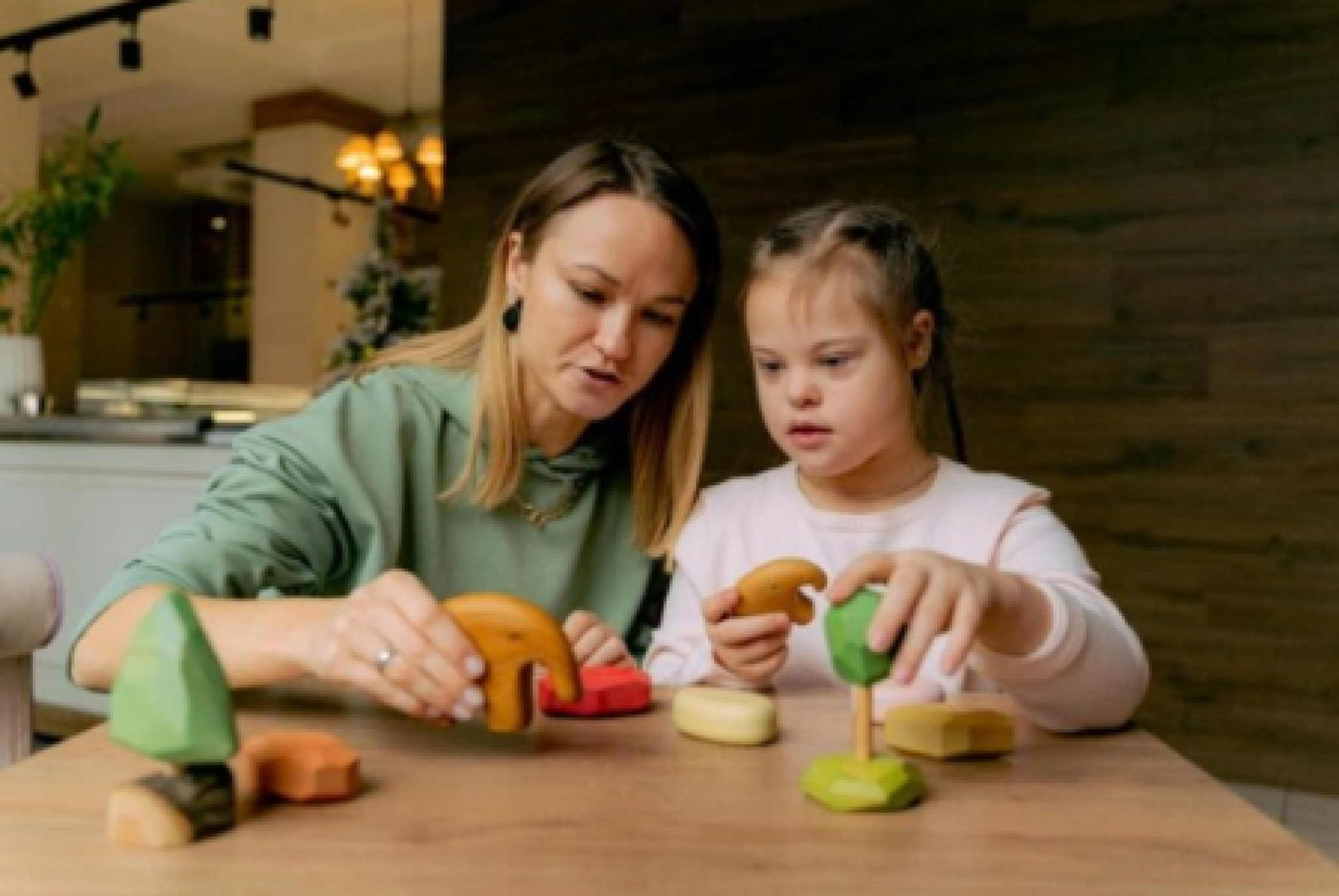 Una caregiver insieme a una bimba con sindrome di Down