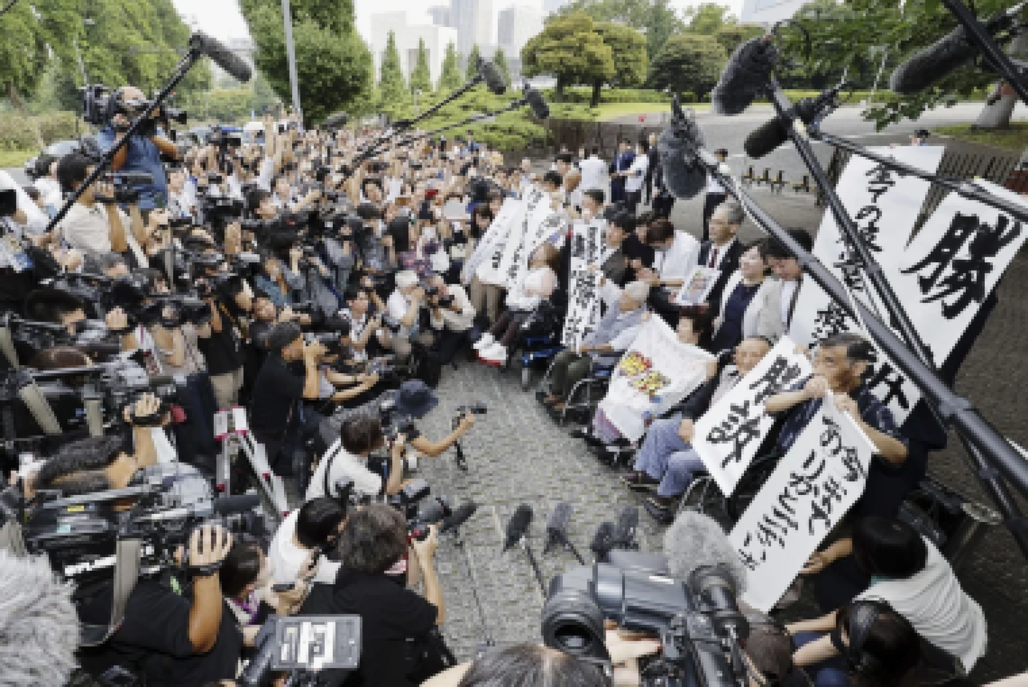 Querelanti, insieme ai loro avvocati e sostenitori, tengono i cartelli con la scritta “Causa vinta” fuori dalla Corte Suprema del Giappone, nel luglio 2024, dopo che la stessa Corte Suprema ha ordinato al Governo di risarcire le migliaia di vittime sterilizzate forzatamente, ai sensi della Legge sulla Protezione Eugenetica, che era stata progettata per eliminare la prole di persone con disabilità (Kyodo News tramite AP)