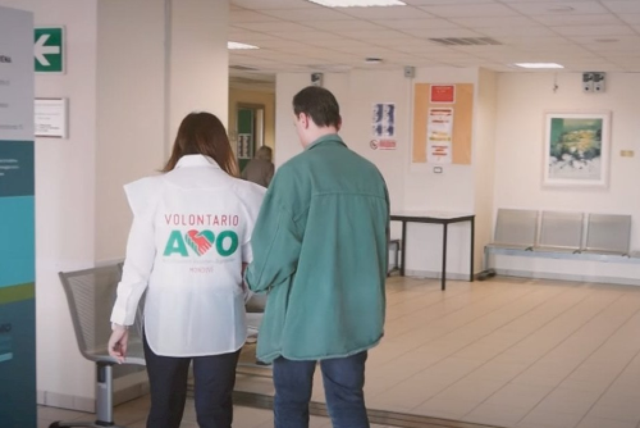 Una persona con disabilità visiva in ospedale, insieme a una volontaria dell'AVO