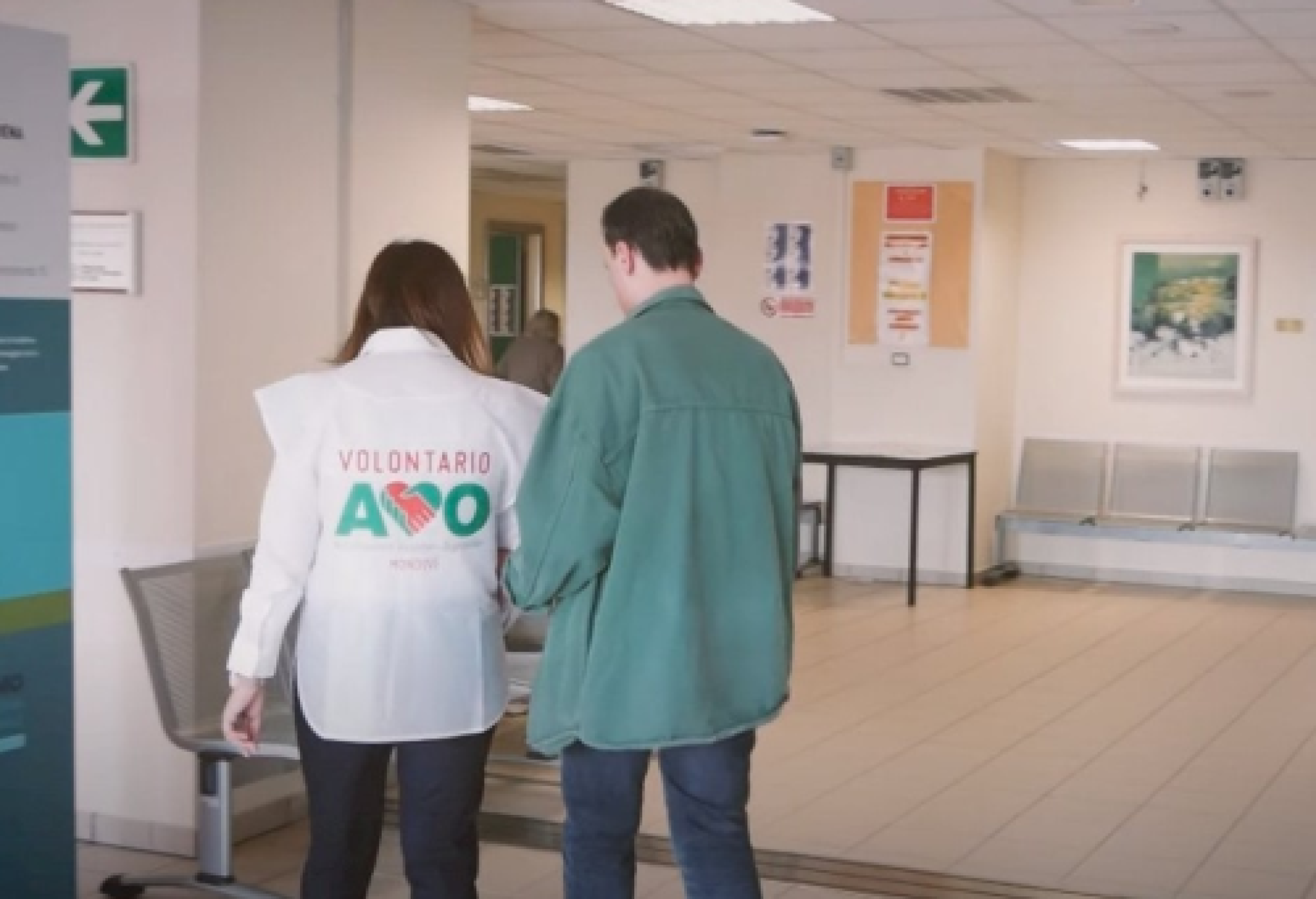 Una persona con disabilità visiva in ospedale, insieme a una volontaria dell'AVO