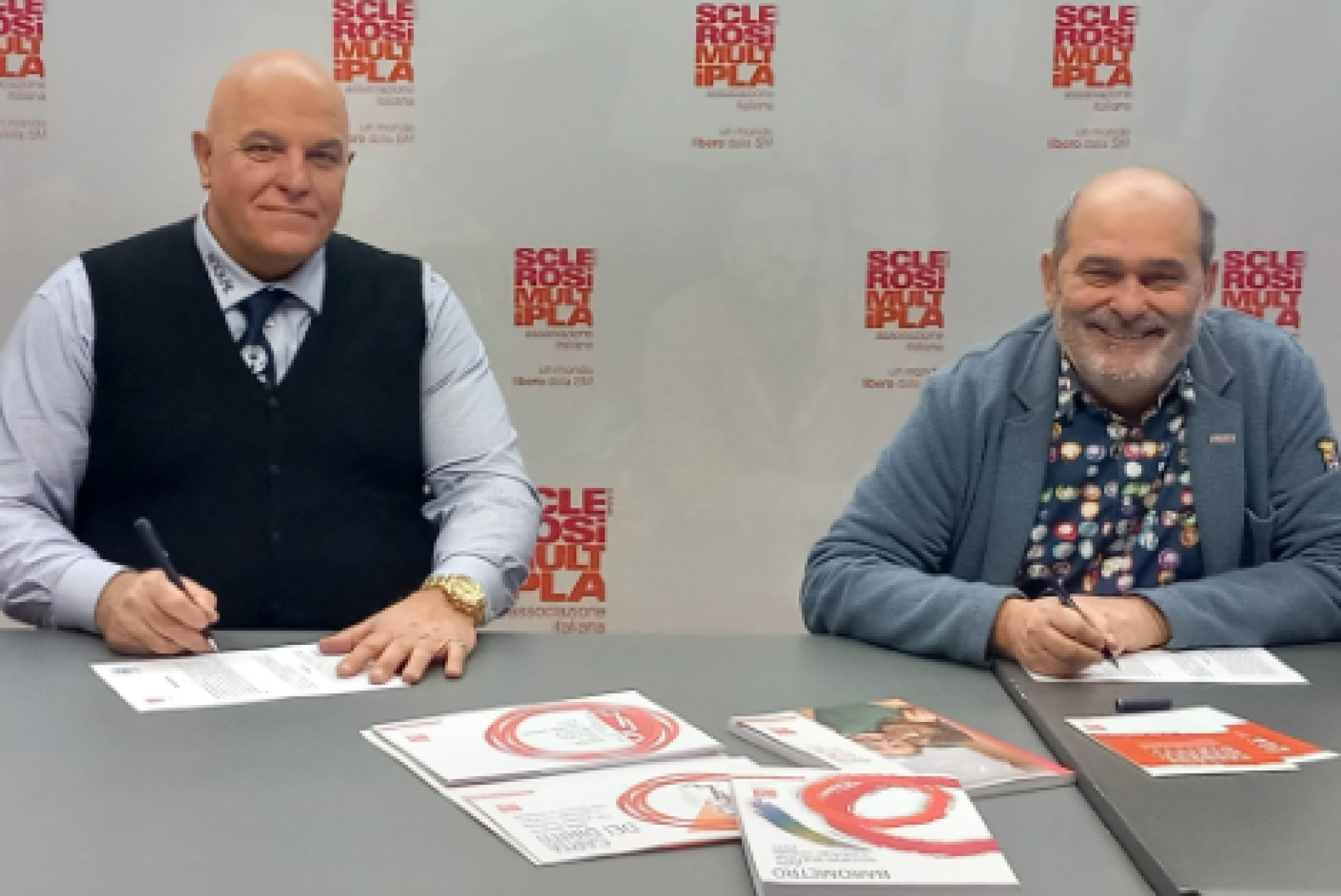 Il presidente dell'AISM Francesco Vacca (a destra) e il presidente dell'ANGLAT Claudio Puppo sottoscrivono il Protocollo d'Intesa tra le due Associazioni
